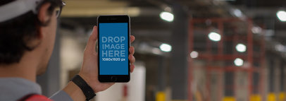 iPhone 6 Plus Mockup in Portrait Position Held by a Construction Worker