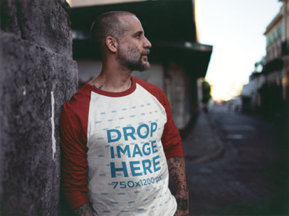 Raglan T-Shirt Mockup of a Tattooed Guy Leaning Against a Wall