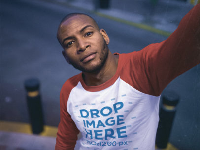 Man Wearing a Raglan Tee Mockup Taking a Selfie