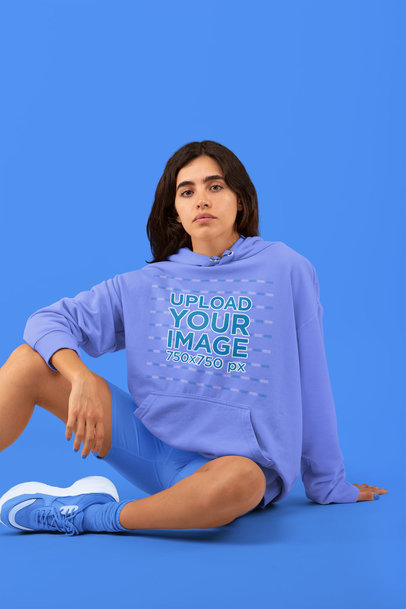 Monochromatic Sweatshirt Mockup Featuring a Woman Sitting in a Studio