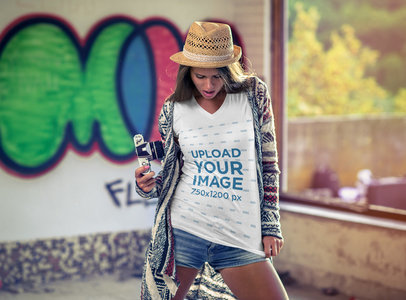 Mockup of a Woman Wearing a V-Neck T-Shirt and Holding a Vintage Camera 