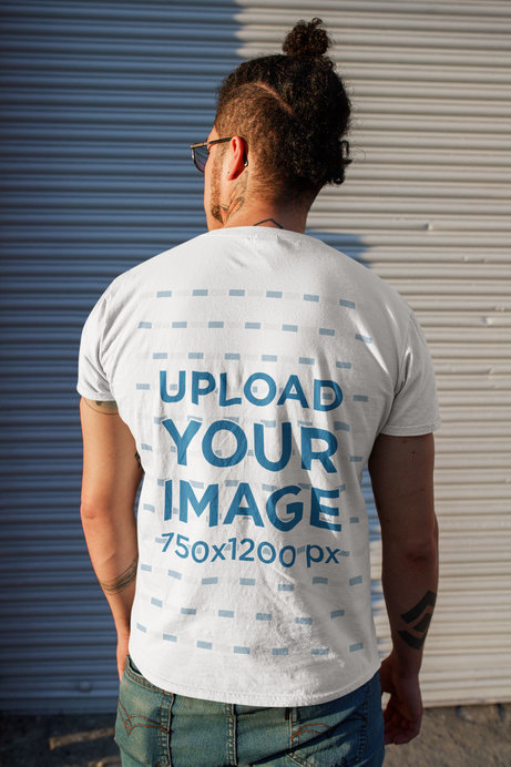 Back View T-Shirt Mockup Featuring a Man With a Head Bun Standing on the Street