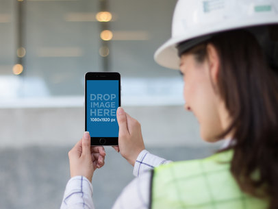 Mockup of a Female Architect Taking a Picture with an iPhone 6 Plus