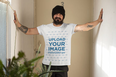 Mockup of a Tattooed Man Wearing a T-Shirt Indoors