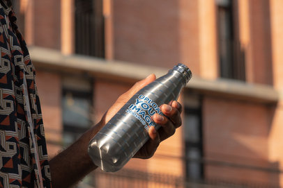 Mockup of a Man Holding a Sublimated Aluminum Bottle Outside
