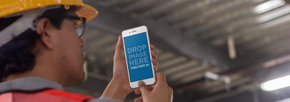 Mockup of a Male Architect Holding His iPhone 6 Plus in Portrait Position at a Construction Site