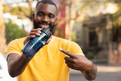 Mockup of a Smiling Man Pointing at a Bike Bottle 