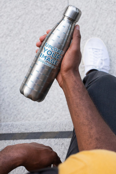 Mockup of a Man Holding an Aluminum Bottle in His Hand