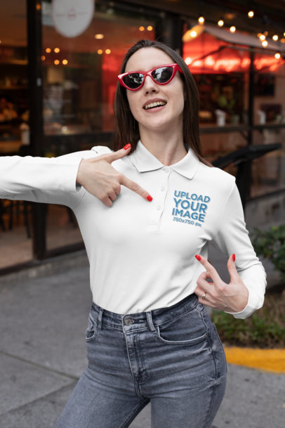 Mockup of a Woman Pointing at the Design on Her Long Sleeve Polo Shirt