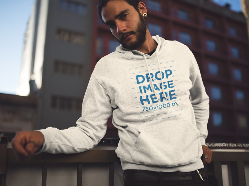 Pullover Hoodie Mockup Featuring a Young Hipster Man Looking Over and Leaning on a Rail