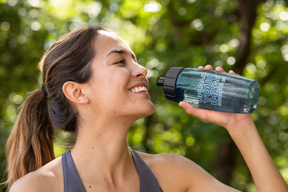 Mockup of a Happy Woman Drinking from a Bike Bottle