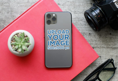 Sticker Mockup of an iPhone 11 Pro Placed Next to a Camera