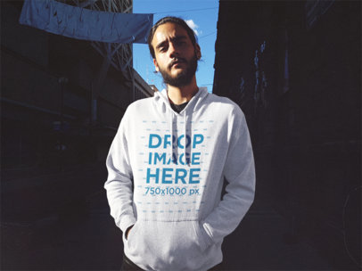 Serious Hipster Guy with a Beard Wearing a Pullover Hoodie Mockup in an Alley