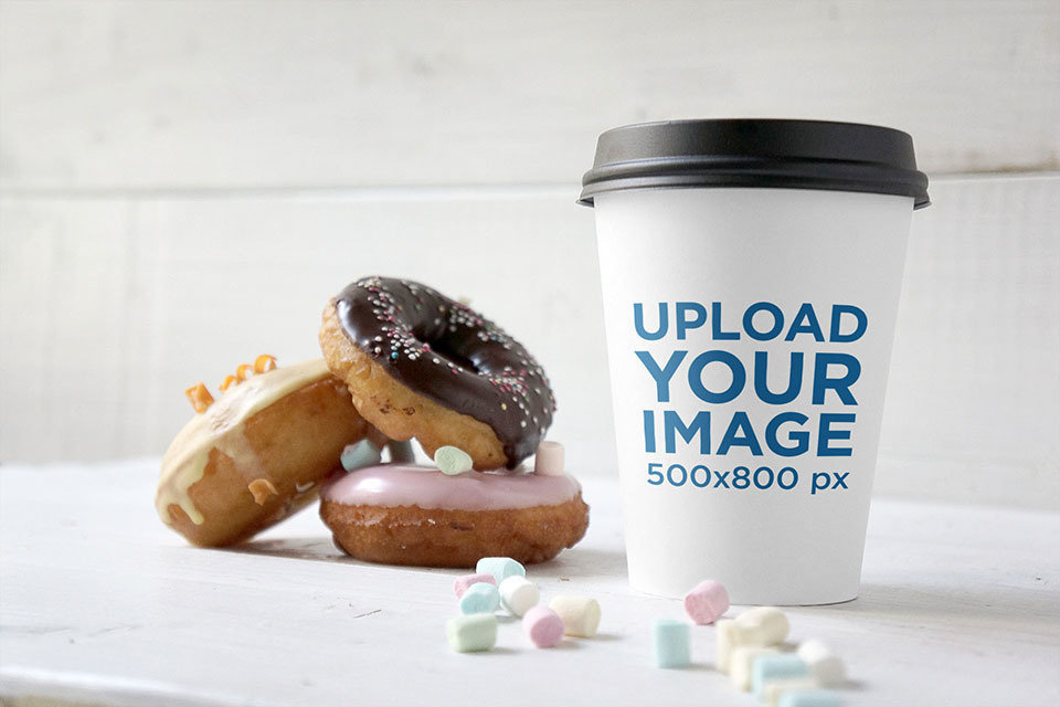 Mockup of a Paper Cup Next to Some Donuts