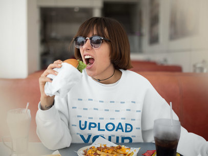 Crewneck Mockup of a Trendy Woman with Sunglasses and Short Hair Eating a Burger