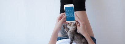 iPhone Mockup of a Tattooed Woman on a Bed with her Kitten