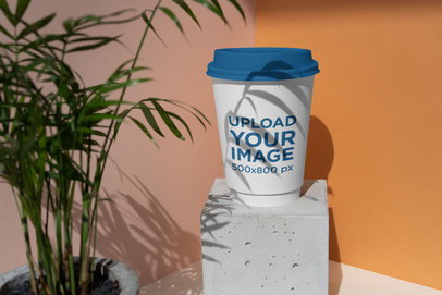 Mockup of a Coffee Cup Featuring a Plant and a Cement Block 3769-el1