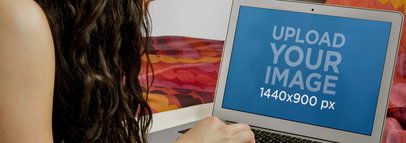 Mockup of a Woman Using a MacBook Air in Bed