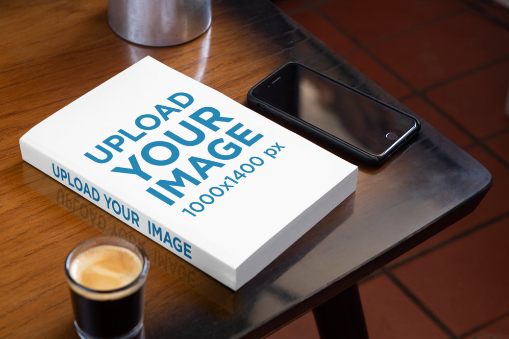 Mockup of a Book on a Table with a Phone and a Coffee