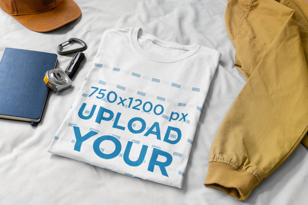 Mockup of a Folded T-Shirt on a Bed with Some Working Tools