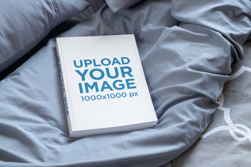 Mockup Featuring a Paperback Book Placed on a Cozy Bed 