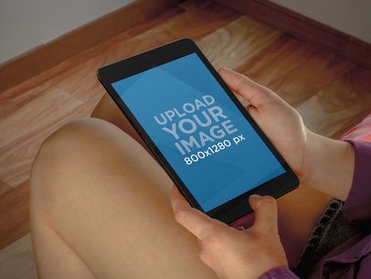 Mockup of a Woman Holding a Nexus 7 in Portrait Position 