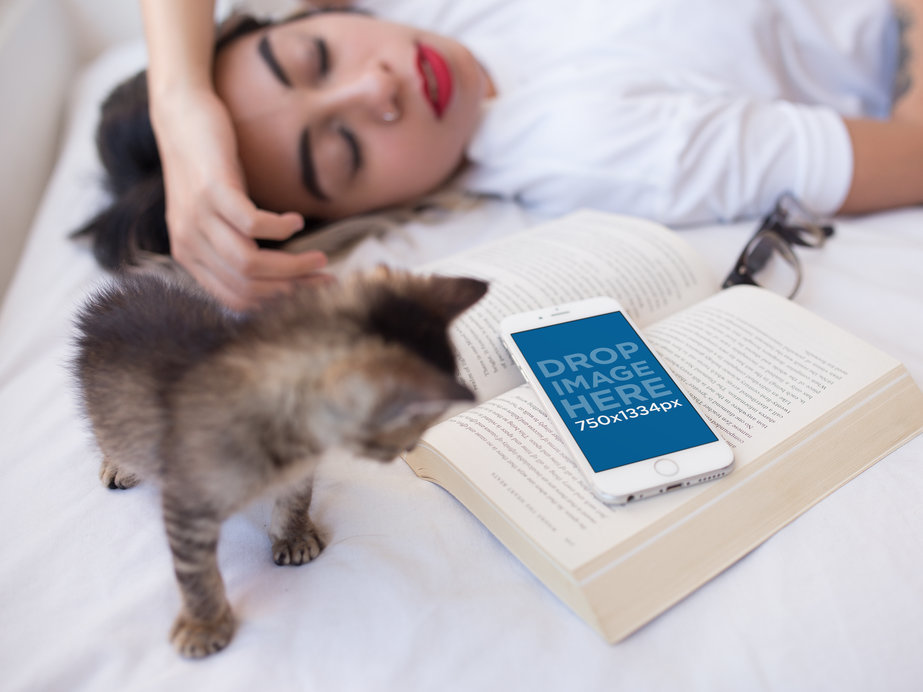 White iPhone 6s Mockup of a Woman Sleeping on her Bed with a Kitten and a Book