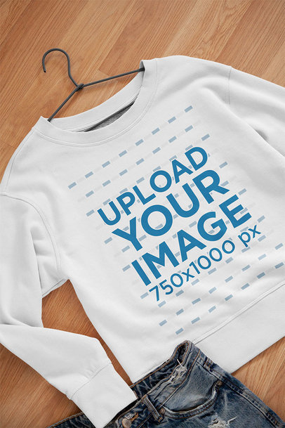 Mockup of a Sweatshirt on a Hanger over a Wooden Surface
