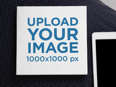 Mockup of a Square Paperback Book Placed Next to a Tablet