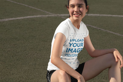 T-Shirt Mockup of a Girl Sitting on a Soccer Field
