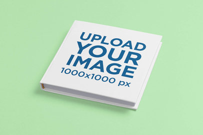 Mockup Featuring a Square Hardcover Book on a Colored Surface 