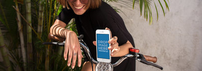 Mockup Featuring a Woman Smiling While Holding an iPhone in a Bike