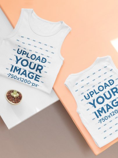 Mockup of Two Kids' Tank Tops Folded Over Colored Platforms 33966
