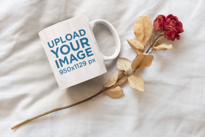 Mockup of a Coffee Mug Placed Next to a Dried Rose