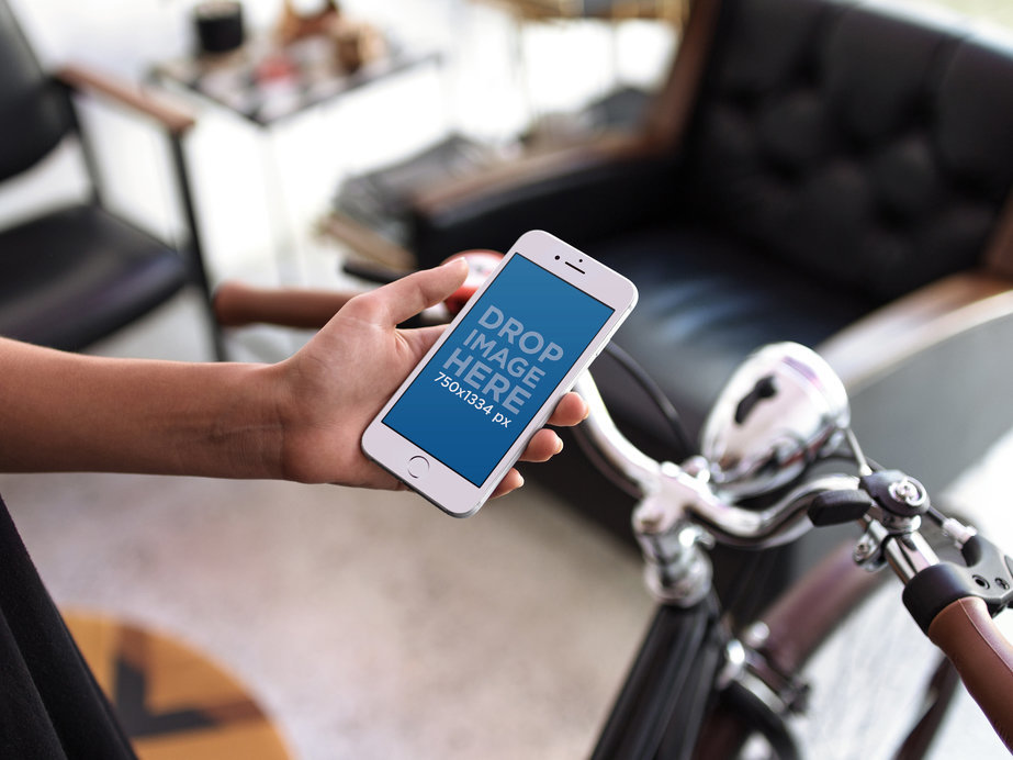 White iPhone 6s Mockup Held by a Man About to Go on a Bicycle Ride