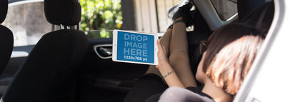 Mockup of an iPad Mini in Landscape Position Held by a Young Woman Relaxing the Backseat of a Car a12946w