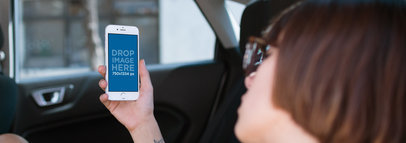 Mockup of a Woman with Short Hair Checking her iPhone 6s in the Back of a Car