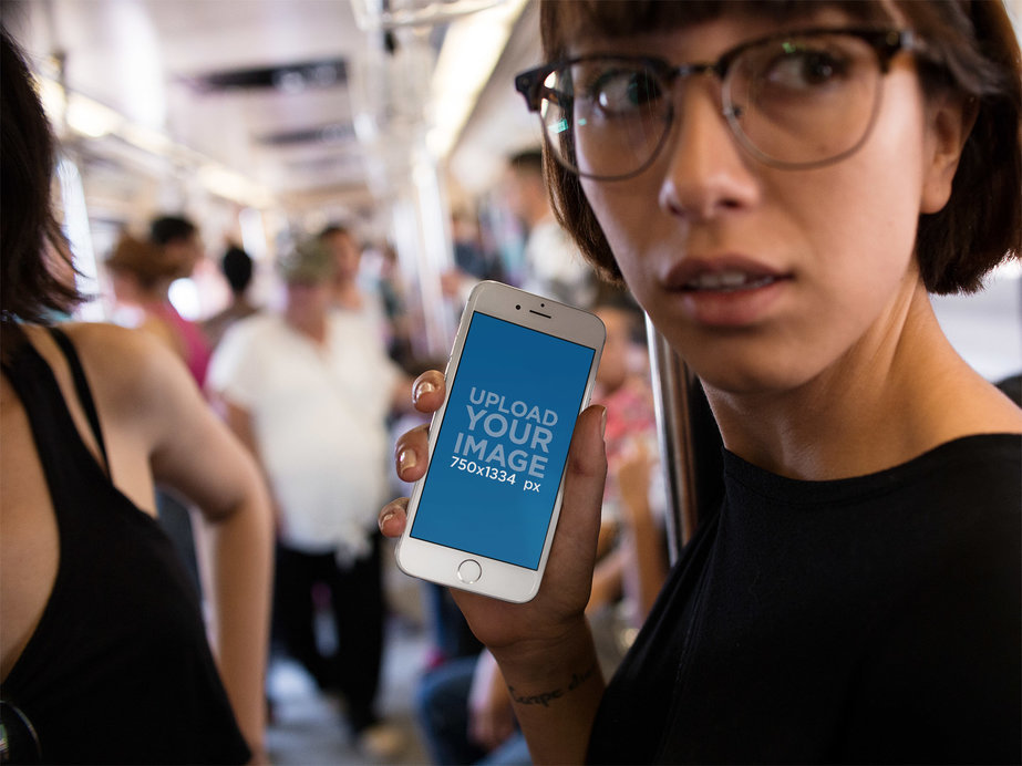Mockup of a Woman Holding an iPhone 6 at the Urban Train