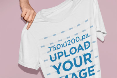 Mockup of Someone Holding a T-Shirt in Front of a Colored Background