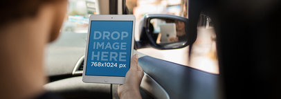 Mockup of a Man Holding an iPad in Portrait Position During a Car Ride 12962wide