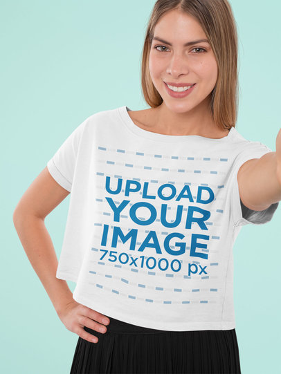 Mockup of a Woman with a Crop Top Tee Taking a Selfie at a Studio