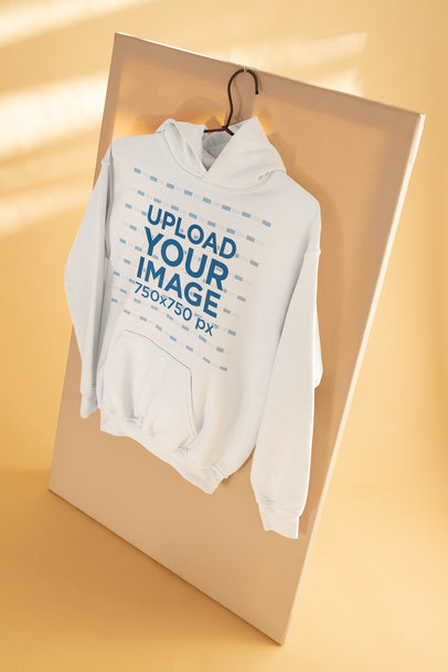 Mockup of a Pullover Hoodie Hanging in a Simple Setting