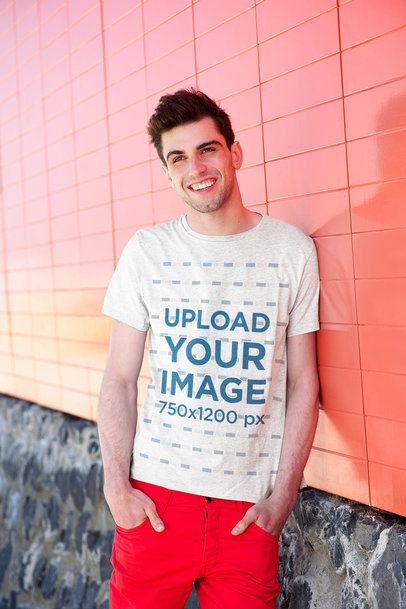 Round Neck T-Shirt Mockup Featuring a Man Leaning over a Colorful Wall