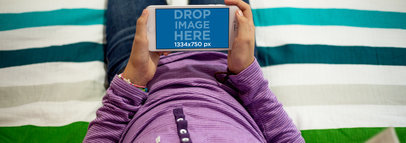 iPhone 6 Mockup in Landscape Position of a Girl Resting on a Bed 12995wide