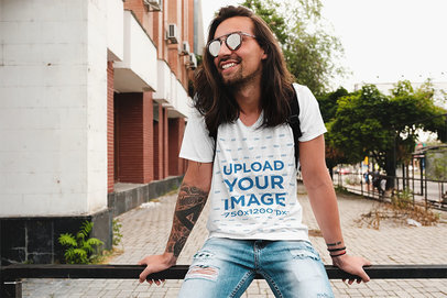 T-Shirt Mockup of a Hipster Man with a Tattooed Arm Sitting on a Handrail 34137-r-el2