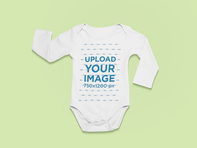 Front-View Mockup of a Long Sleeve Onesie Against a Flat Surface
