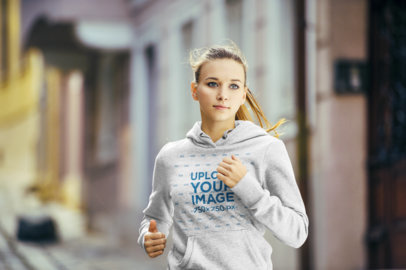 Pullover Hoodie Mockup of a Woman Jogging by a Street