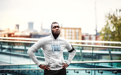 Mockup of a Jogger Wearing a Hoodie by an Urban Bridge