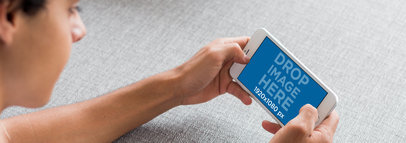 Young Man Lying on a Couch Playing with his iPhone 7 Plus Mockup
