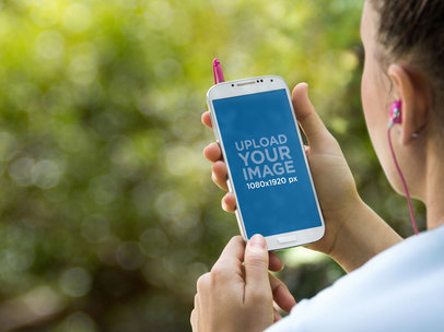 Mockup Featuring a Woman With Earphones Using a  Samsung Galaxy 